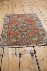 Distressed pile of the vintage Oushak rug with worn madder root, royal blue, and ivory tones.
