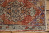 Distressed Oushak rug corner with madder root field, faded floral motifs, and visible fringe.
