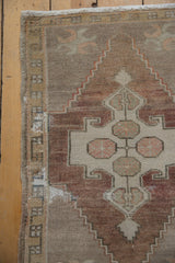 Distressed vintage Oushak rug showing muted geometric pattern, low pile, and worn selvage.
