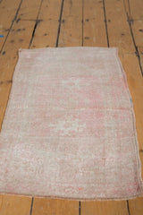 Distressed Oushak rug featuring its faded rose and ivory palette and even short pile.
