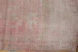 Distressed texture of even short pile vintage Oushak rug in soft rose, pink, and ivory hues.