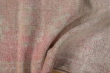 Close-up of distressed Oushak rug pile with rose, blush, and ivory tones.