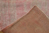 Vintage distressed Oushak rug's ivory and rose short pile, woven reverse, and intact selvage.