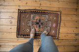 Distressed vintage Oushak rug's primitive geometric pattern with saffron, pink, and brown, showing even wear.