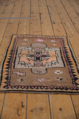Distressed Oushak rug showing primitive geometric cartouche, coffee brown, pink, and worn pile.