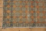 Distressed Oushak geometric floral motifs in sandalwood and beige with areas of visible foundation.