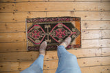 Distressed vintage Oushak rug showcasing vibrant pink, tangerine, and aubergine medallion detail.