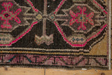 Vintage distressed Oushak rug corner with abrashed spandrel, vibrant pink motifs, faint foundation.