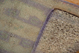 Distressed vintage Oushak rug's lilac selvage and visible hand-knotted foundation.