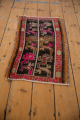 Distressed Oushak rug close-up showing stylized pink, tangerine, and charcoal motifs within the serpent border.