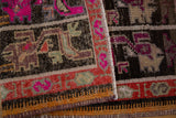 Distressed vintage Oushak rug close-up showing knot heads, vibrant fuchsia, and rust geometric pattern.