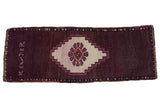 Distressed Oushak rug runner: aubergine field, ivory stepped medallion, weaver inscription.