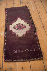 Vintage distressed Oushak rug with weaver inscription on deep aubergine pile and geometric border.