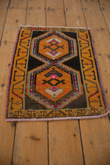 Distressed vintage Oushak rug with saffron yellow and charcoal geometric medallion, pink details, purple selvage.