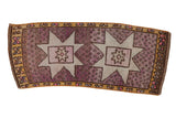 Distressed vintage Turkish Oushak rug with pale starbursts and mauve speckled field.