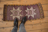 Distressed vintage Oushak rug's speckled mauve field, starbursts, and even pile wear.