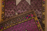 Distressed Oushak rug pile showing even wear, mauve, aubergine, and yellow patterned border.