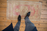 Distressed vintage Oushak rug with muted blush pink and sand abrashed ground.