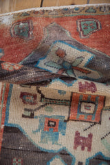 Distressed Oushak rug's low pile with rustic rust, turquoise, and beige patterns.