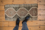 Distressed Oushak rug mat with soft patina, featuring muted silver, beige, and charcoal patterns.