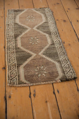 Distressed Oushak rug's intact side selvage, worn budded blossom in muted tones.