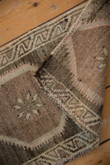 Distressed vintage Oushak rug pile with time-softened silver, beige, and rose blossom motif.