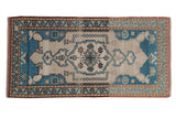 Distressed vintage Oushak mat runner with a sky blue medallion and ivory field.