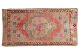 Distressed Oushak rug with blush floral medallion, ivory field, bright turquoise, fuchsia accents. 1'10