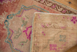 Distressed Oushak rug pile with blush, fuchsia, and turquoise, alongside its hand-knotted foundation.