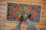 Distressed pile of a vintage Oushak rug, showing tree of life, faded terracotta, green tones.