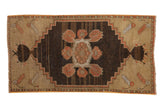 Distressed vintage Turkish Oushak rug with stepped medallion and primitive dusty rose florals.