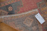 Vintage distressed Oushak rug fold showing worn pile, woven foundation, and fringe.