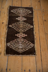 Close-up of the distressed Kars rug showcasing geometric hook and latch motifs and secured side.