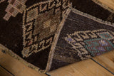 Vintage Kars rug's folded corner: short brown pile, beige motifs, and secured woven edge.