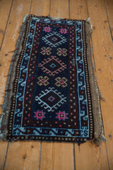 Dark blue vintage Anatolian rug corner showing geometric pattern and tattered fringe.