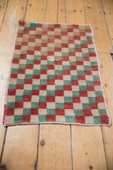 Distressed Oushak rug corner, bright turquoise, red, and green checker pattern with wear.