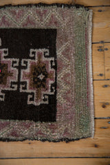 Distressed vintage Kars rug corner, chocolate brown hooked motifs, multi-toned border, intact selvage.