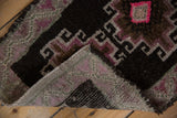 Distressed vintage Kars rug with chocolate, mauve, and bright pink geometric patterns, showing hand-knotted reverse.
