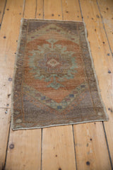 Distressed vintage Oushak rug corner showing worn pile, intact selvage, and muted earthy tones.
