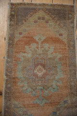 Distressed vintage Oushak rug texture showing muted sandalwood, seafoam hues, and intact side cord.