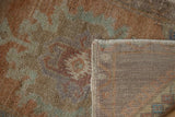 Visible knot heads on distressed Oushak rug pile, alongside its hand-knotted foundation.