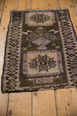 Distressed Kars rug's hand-knotted pile texture and geometric side border in bronze and beige.
