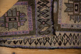 Distressed Kars rug showing rich purple, beige, and bronze geometric border and secure selvage.