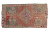 Distressed Anatolian rug with stepped medallion, blush abrash field, and corner plant motifs.