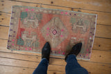 Vintage distressed Anatolian rug mat with stepped medallion and blush, beige tones, underfoot.