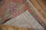 Distressed vintage Anatolian rug's worn pile, bright pink hues, and woven foundation.