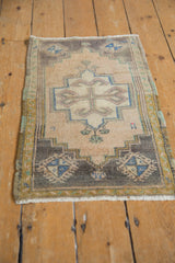 Worn pile and geometric corner spandrel of a vintage distressed Oushak rug in mauve, beige, and blue.