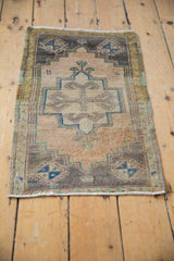 Distressed Oushak rug's stepped center medallion, with even wear and soft mauve, beige, ivory tones.