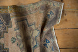 Detail of the vintage distressed Oushak rug's textured pile and geometric blue designs.