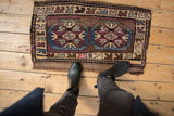 Distressed Kars rug mat with plum and pale denim blue geometric medallions on wood.